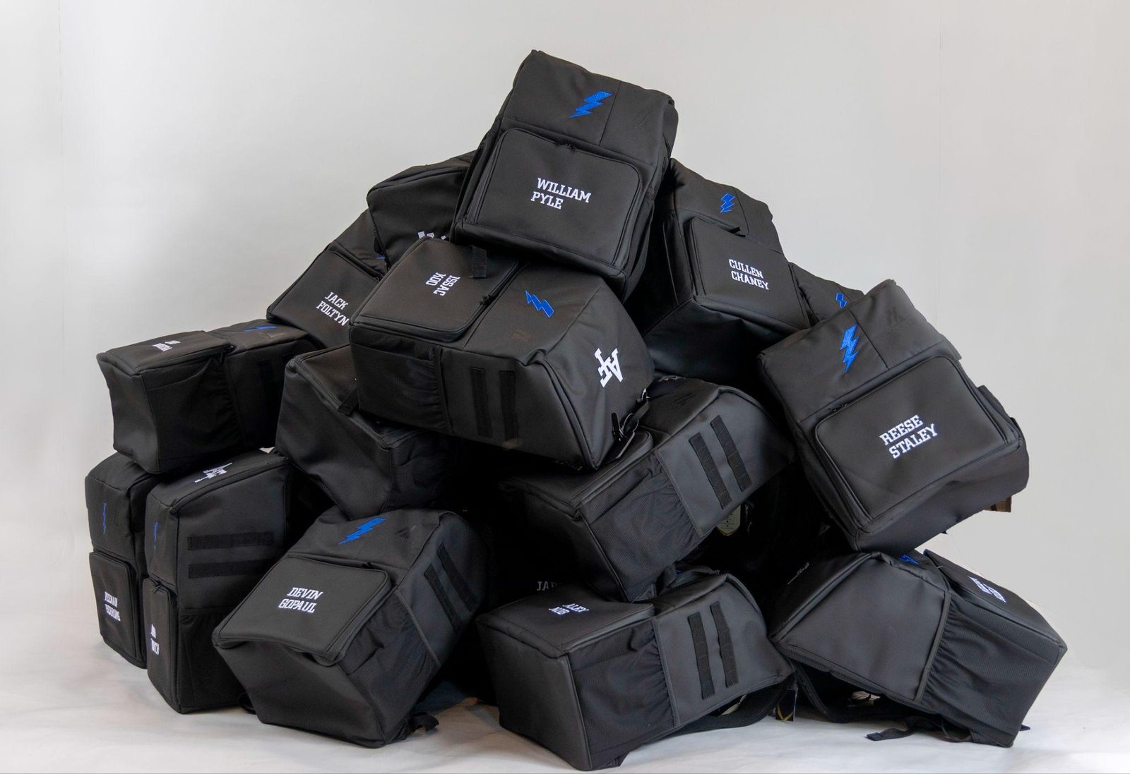 A pile of custom team gymnastics backpacks with heat pressed sublimated logos